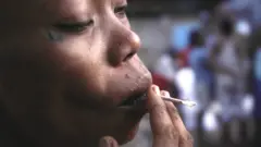 Mulher fuma cigarro de kush