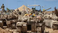  ဂါဇာနဲ့ ကပ်ရက် အစ္စရေးနိုင်ငံ တောင်ပိုင်းနယ်စပ်မှာ တပ်စွဲထားတဲ့ တင့်ကားတွေကို အစ္စရေး စစ်သားတွေ စက်ပြင်ဆင်နေပုံ