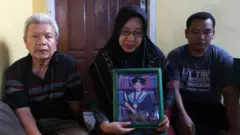 Hasna Dani Paita (tengah) mendekap bingkai foto anak pertamanya, Wahyudin S Lamampara, yang meninggal dunia dalam ledakan tungku smelter nikel di PT ITSS Morowali pada Minggu (24/12/2023)