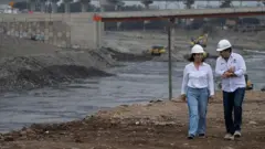 A presidente do Peru, Keiko Fujimori, supervisiona obras nas margens de um rio