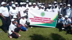 Bamwe mu bari n'abahoze mu ishyirahamwe ry'impunzi muri Zambia, bafite icyapa kijyanye n'umunsi mpuzamahanga w'impunzi