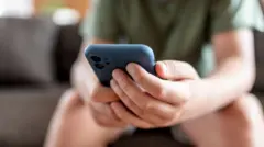 ስልኩን የሚመለከት ታዳጊ እጅ