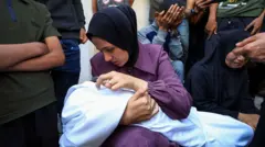 Una mujer acunando a su hijo muerto.