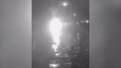 Яркий белый свет на черно-белом снимке указывает на возможную точку взрыва. Очертания судна почти не различимы, но на переднем плане видна вода. Это указывает на то, что фотография сделана с другого судна. 