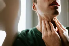 Fotografaijogos de azar como ganharhomem branco segurando a pele do pescoço com as duas mãos