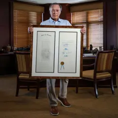 O filantropo Miguel 'Mike' B. Fernández mostra a lei de matrícula estadual para imigrantes sem documentos que ele ajudou a aprovar, mas que, agora, ficou sem efeito