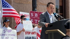 Jason Yuan da un discurso en un atril, con manifestantes detrás de él sosteniendo carteles.