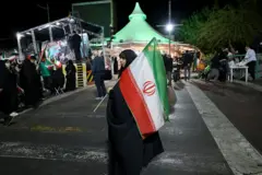 Mwanamke akiwa amebeba bendera ya Iran