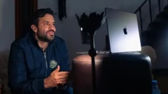 Marçal sorrindo em frente a laptop, aparentemente gravando live