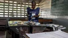 Umukozi w'akanama k'amatora ari mu biro by'itora