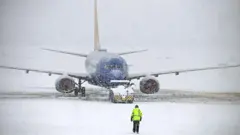 Самолет стоит на заснеженном и обледеневшем взлетном поле.