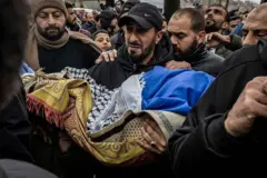 Un hombre carga el cuerpo de Mohammed Bani Odeh, de cinco años, durante el funeral de cuatro miembros de la misma familia muertos en manos de las fuerzas israelíes.