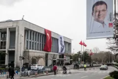 İBB'nin Saraçhane'deki merkez binası önünde yürüyenler ve bir polis 