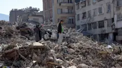 በቱርክ ርዕደ መሬቱ ያስከተለው ውድመትን የምትመለከት ሴት