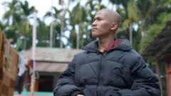 ජැකට් එකක් ඇඳ සිටින තරුණයෙක්