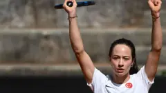 Sönmez, üzerinde Türkiue bayraklı formayla raketini havavaya kaldırmış ve kutluyor