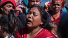 Seorang perempuan Nepal menangis di pemakaman korban gempa.