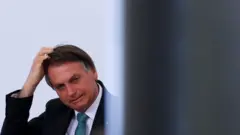 Bolsonaro coça a cabeça