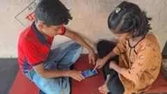ఫోనులో గేమ్స్ ఆడుతున్న పిల్లలు