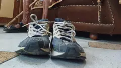 Os tênis de corrida azul e branco de Singh com seu nome