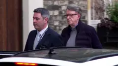 Peter Mandelson sendo escoltado