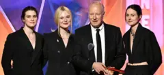 Inga Ibsdotter Lilleaas, Elle Fanning, Stellan Skarsgård e Renate Reinsve recebem o prêmio de melhor filme intergeracional/estrangeiro por Valor Sentimental, no palco do Movies for Grownups Awards 2026, organizado pela AARP, em Los Angeles. Todos vestem preto.