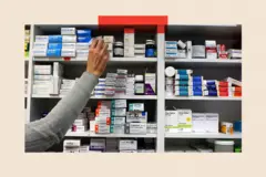 Un farmacéutico repone los estantes de una farmacia.