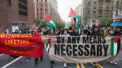 متظاهرون يحملون لافتة احتجاجية تضامنا مع الفلسطينيين في مدينة نيويورك، 18 أبريل/ نيسان 2024