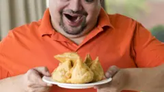 এক ব্যক্তির সামনে এক থালা সামোসা