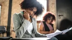 Mulher fazendo prova em sala de aula