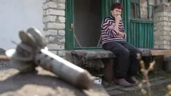 Жінка на зруйнованому подвір'ї, Луганська область