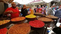 أشخاص يرتدون كمامات في أحد الأسواق