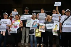 Familiares de presos políticos de pie y pegados en grupo. Llevan camisetas donde se lee "liberern a todos los presos políticos" y carteles donde pone "el rodeo es tortura", "Cierren el rodeo" y fotos de familiares.