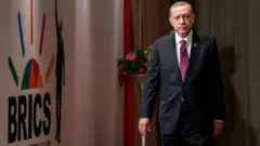 Le président turc Recep Tayyip Erdogan arrive pour assister à une réunion de session lors du 10e sommet des BRICS, le 27 juillet 2018 à Johannesburg, en Afrique du Sud.
