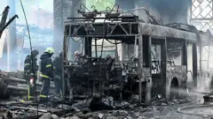Ukrainian rescuers work to extinguish a fire in a trolleybus depot following a drone strike in Kharkiv on May 30, 2025, amid the Russian invasion of Ukraine.