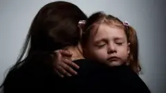 A small child holding her mother