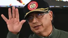 Petro acena e usa um boné que diz "Presidente da Colômbia"