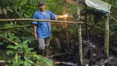 Penduduk Kampung Cisadon di samping kincir air pembangkit listrik.