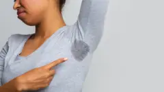One woman raise her hand to show her armpit