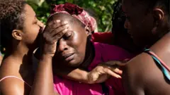 Mujeres se lamentan en Bahamas tras el paso de Dorian