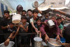 أطفال فلسطينيون يصطفون لتلقي طعام من مطبخ خيري في مخيم النصيرات وسط غزة، 15 يوليو/ تموز 2025.

