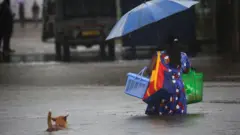 A woman walks through a flooded street in Colombo, on October 15, 2022