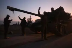 عدد من مسلحي المعارضة يلتقطون صورا لدى دخولهم حلب
