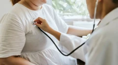 پزشک در حال معاینه قفسه سینه زنی با گوشی استتوسکوپ