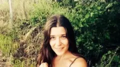 妮娜·庫蒂娜的特寫照片，她在綠色背景下對著鏡頭微笑。