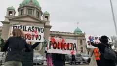 Protest ispred skupštine, na slici transparenti na kojima piše "Tužilaštvo" i "Policija"