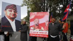 राजशाही के समर्थक पूर्व राजा ज्ञानेंद्र बीर बिक्रम शाह और उत्तर प्रदेश के सीएम योगी आदित्यनाथ को पोस्टरों के साथ काठमांडू के त्रिभुवन हवाई अड्डे के बाहर. 