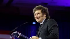 Milei discursando e sorrindo