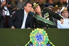 Bolsonaro e Freire Gomes sentados em evento, conversando