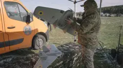 Чоловік у камуфляжі тримає в руках дрон